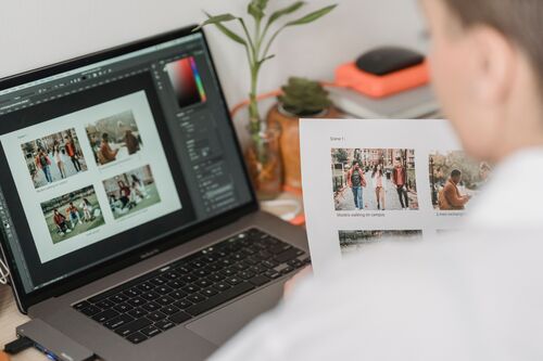 Visual content SEO: person comparing printed photos with images on a laptop 